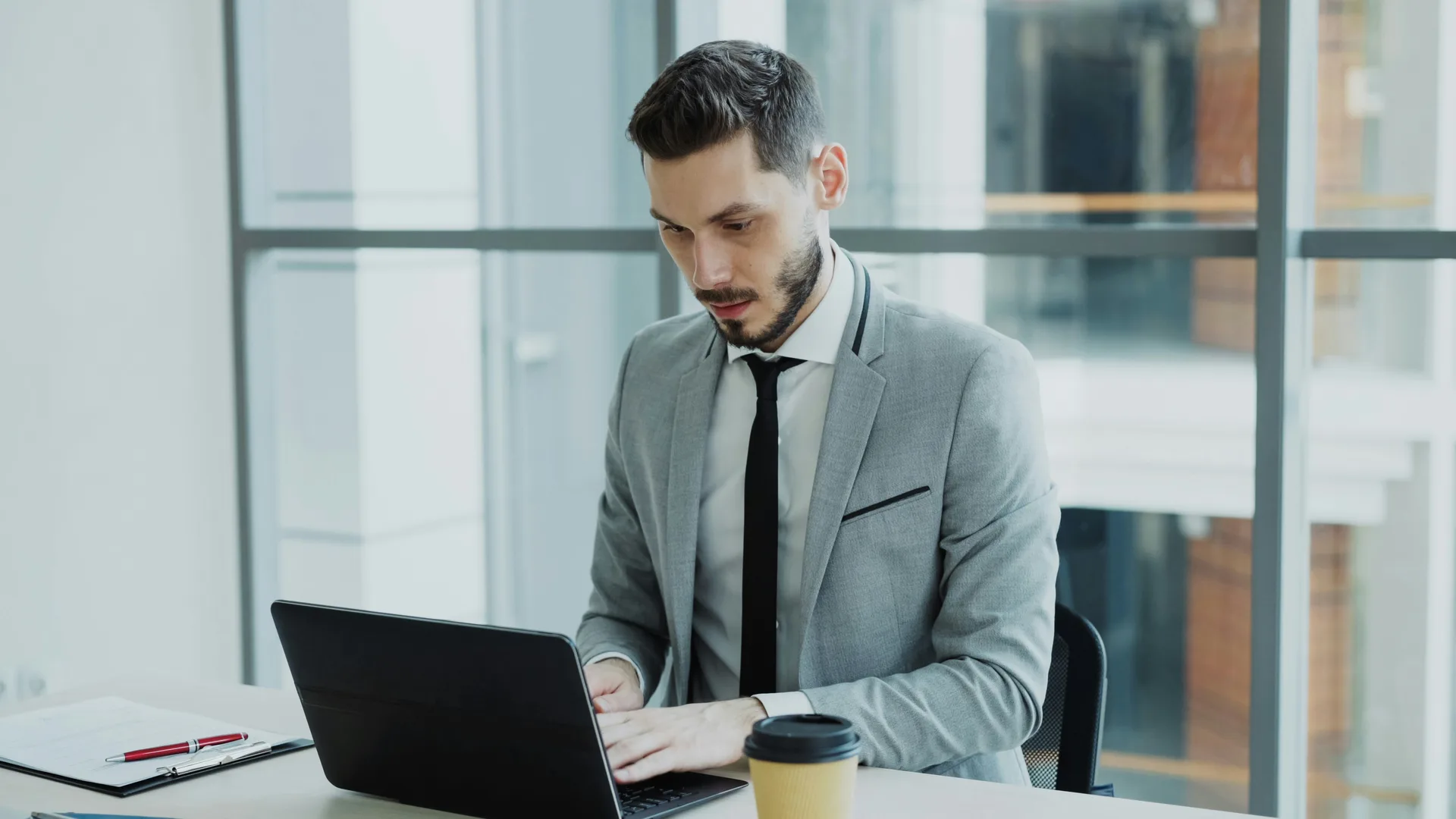 Young businessman using laptop computer in modern office, representing South African business growth and digital presence